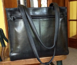 $2 leather handbag. I've carried this for three years now. It does a fit a good-sized book, which is an important feature.
