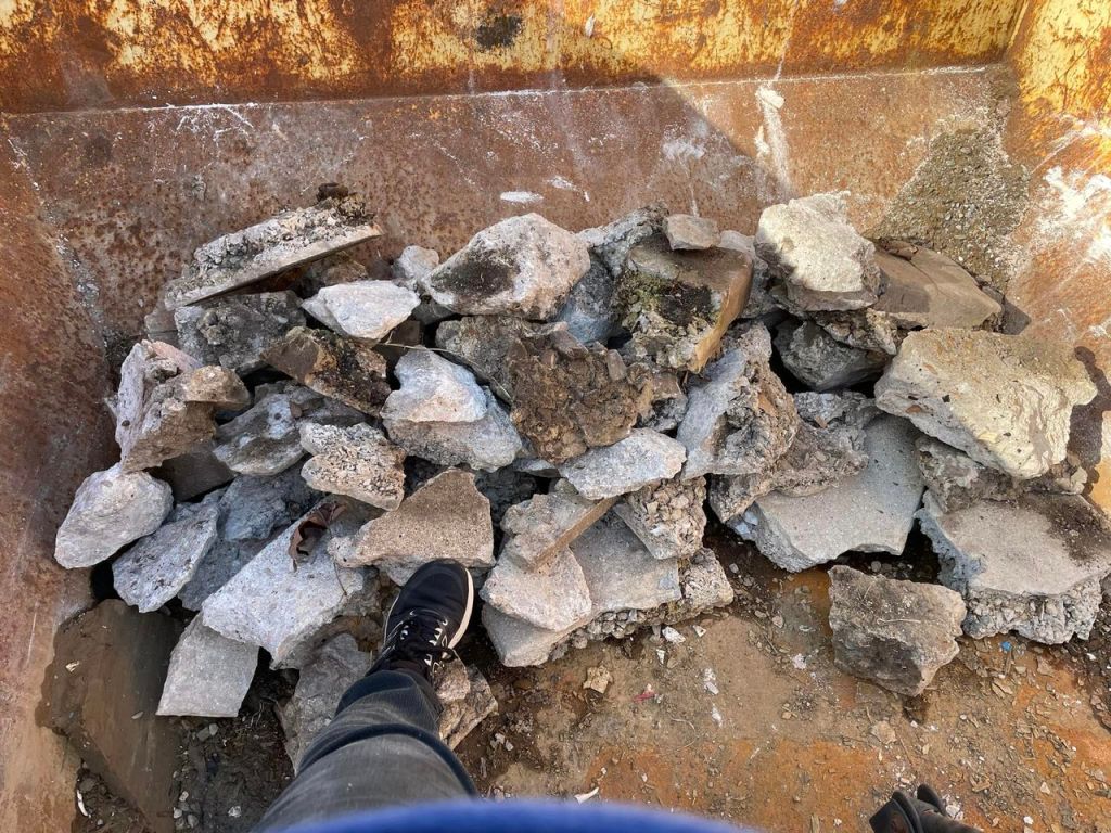 Chunks of concrete piled inside a dumpster.